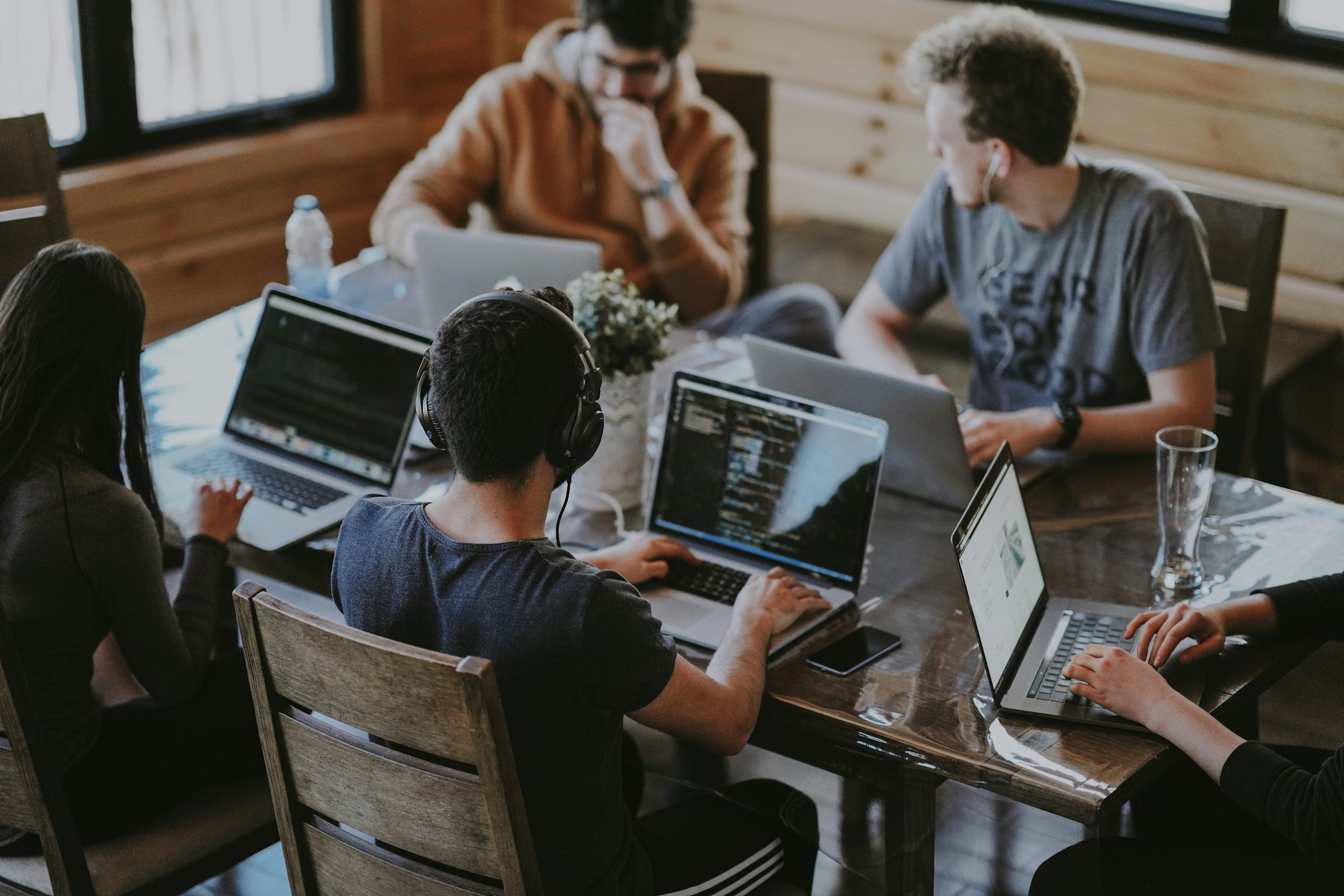 A team working together around laptops at a shared table