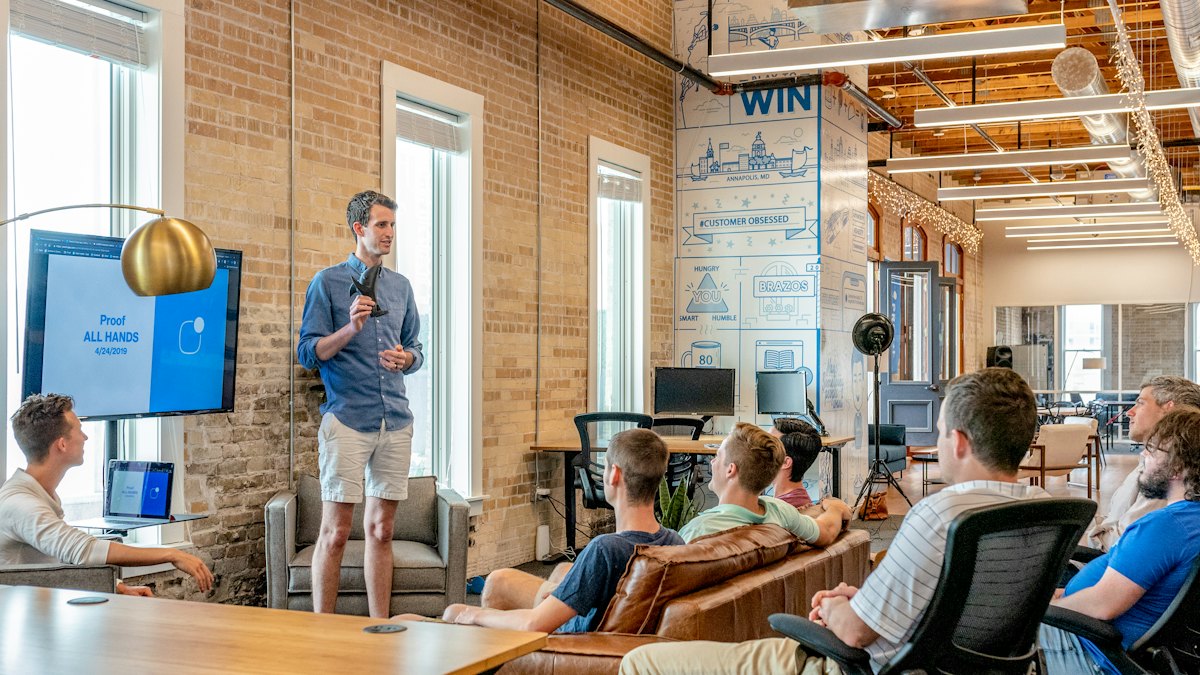 A speaker presenting to a small audience in a bright studio