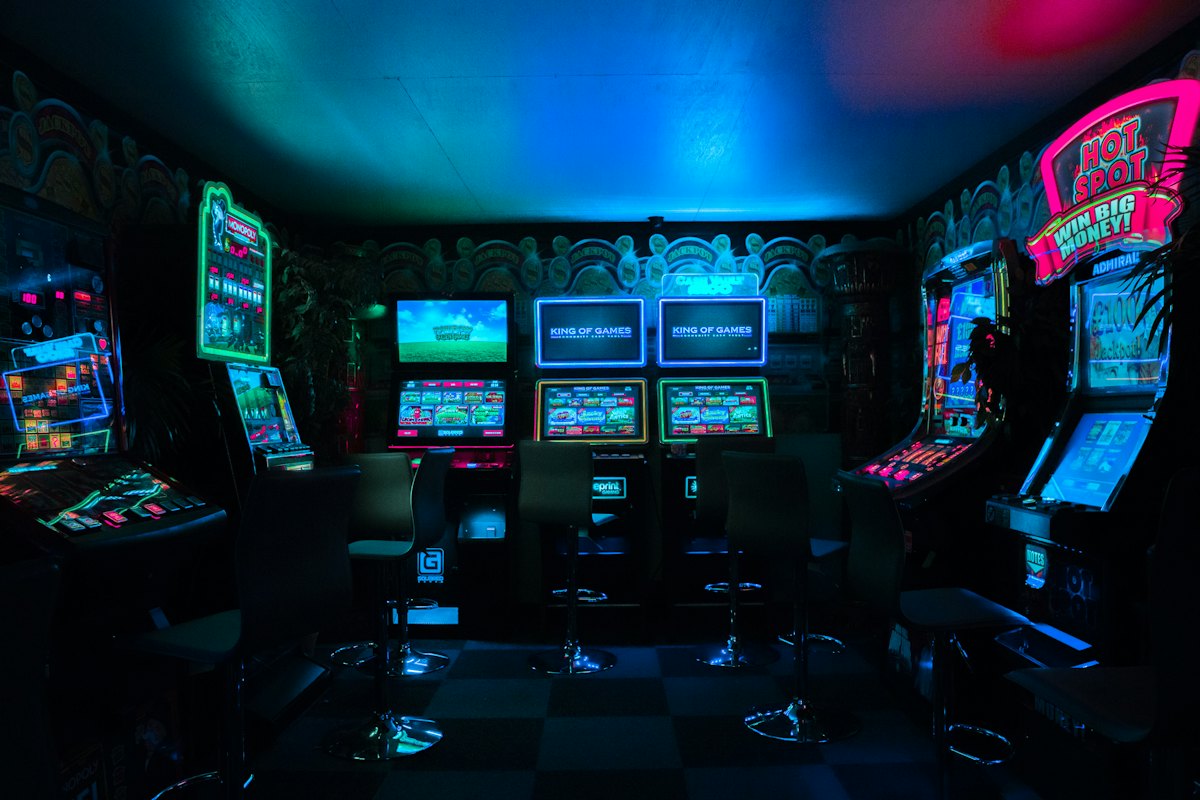A neon-lit arcade room full of game cabinets