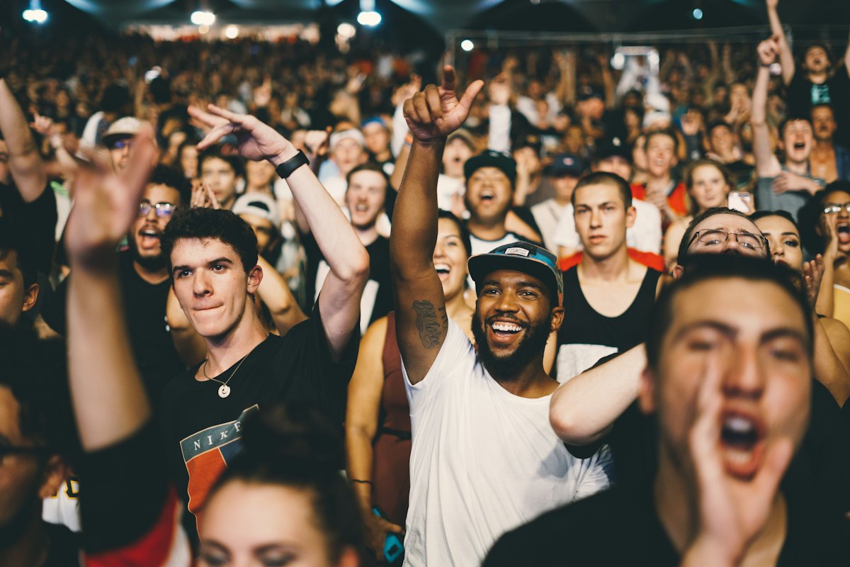 A crowd cheering with arms in the air