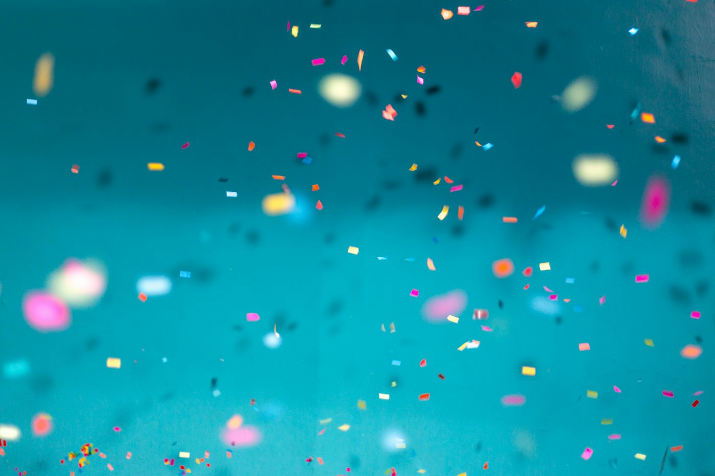 Colourful confetti floating against a teal background